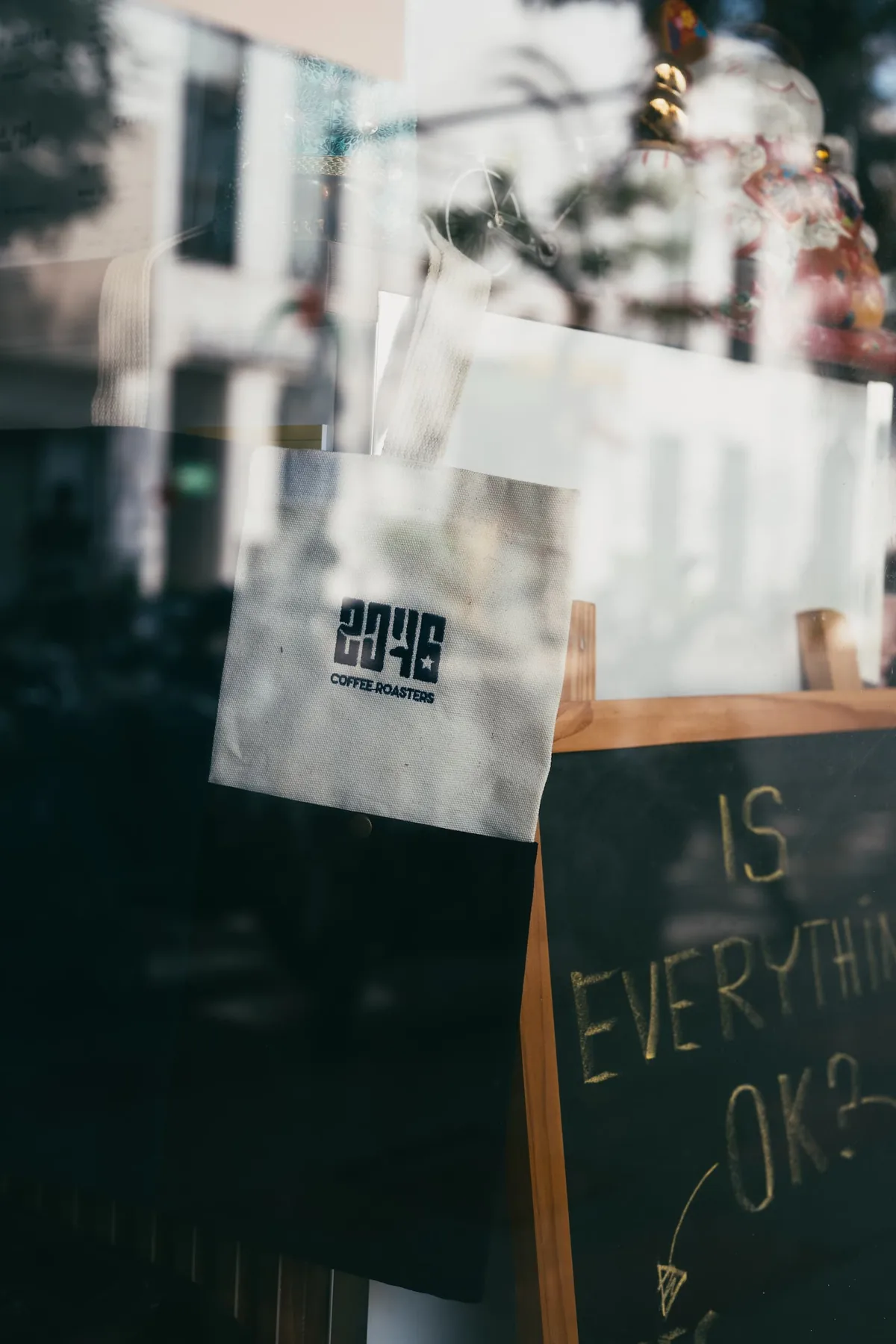 Túi 2046 Coffee Roasters bên khung cửa quán